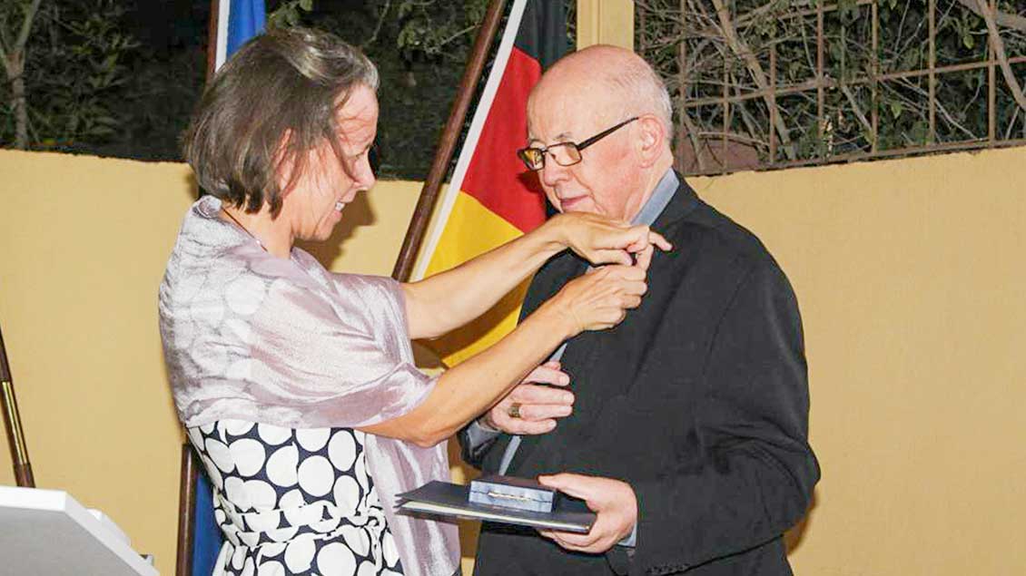 Isabel Hénin verleiht Bischof Martin Happe das Bundesverdienstkreuz.