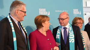 Die Schals, die Thomas Sternberg (links) und Markus Lewe auf diesem Foto mit Kanzlerin Angela Merkel tragen, sind nun im Stadtmuseum. | Foto: Michael Bönte