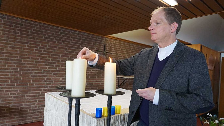 Pater Roman Fries zündet Kerzen an