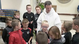 Kinder im Trainingsanzug gratulieren Pater Philip Muryne nach der Priesterweihe.