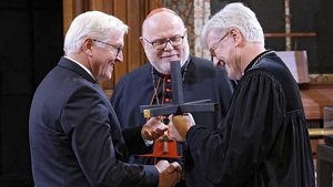 Bundespräsident Frank-Walter Steinmeier erhält ein Kreuz von Kardinal Reinhard Marx und Bischof Heinrich Bedford-Strohm (von links). | Foto: epd