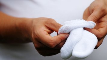 Frau faltet Babysöckchen