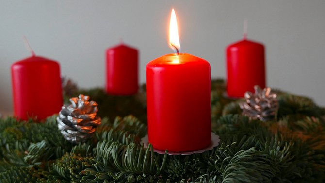 Adventskranz mit einer brennenden Kerze