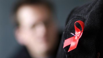Eine Aids-Schleife am Rever einer Cordjacke.