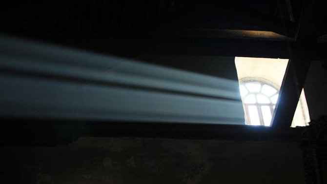 Ein Sonnenstrahl schießt durchs Fenster in den dunklen Raum. Aufgenommen in der Geburtskirche in Betlehem.