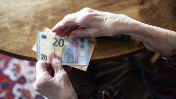Senior hält Geld in der Hand