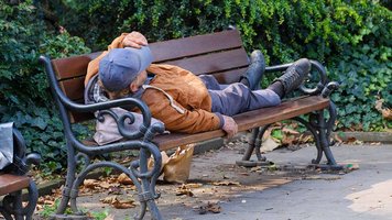 Obdachloser auf einer Parkbank