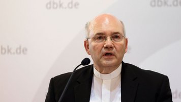 Bischof Helmut Dieser spricht in ein Mikrofon.