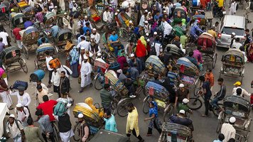 Viele Menschen sind auf einer Kreuzung in Dhaka, Bangladesch, zu sehen.