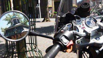 Die Basilka in Kevelaer wird im Rückspiegel eines Motorrads gezeigt.