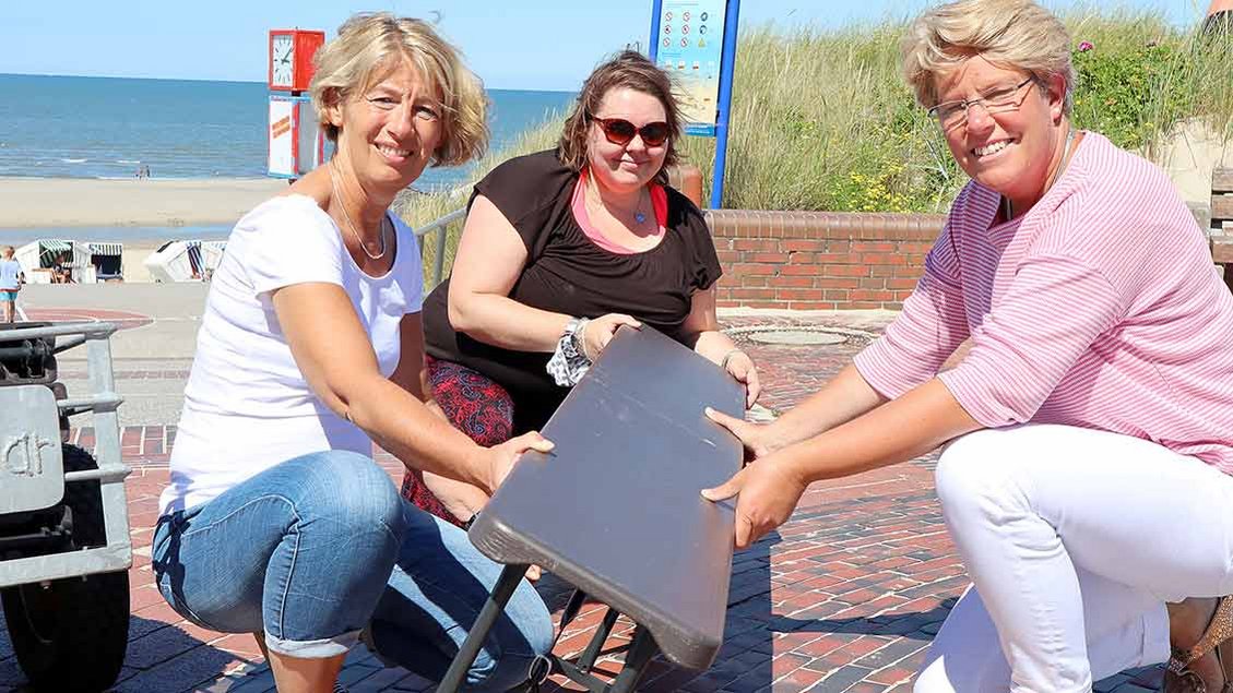 Anke Bartel, Sophia Maria Menner und Anne Nöcker (von links) bringen Sitzbänke zum Strand. | Foto: Michael Rottmann