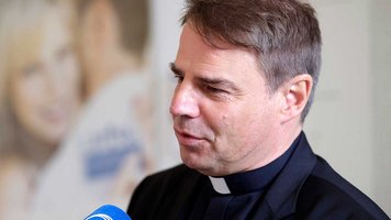 Bischof Stefan Oster spricht in ein Mikrofon