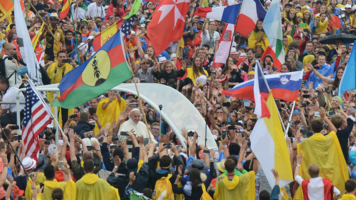 Papst Franziskus im Papamobil umringt von jungen Menschen.