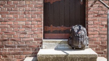 Ein Rucksack steht vor einer Kirchentür.