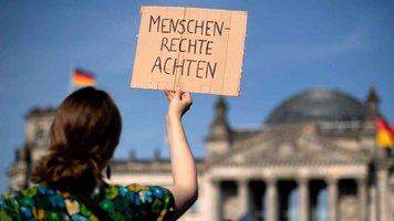 Eine Frau demonstriert für Menschenrechte vor dem Bundestag