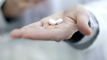 Zwei Tabletten liegen auf einer Handfläche