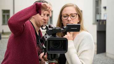 Zwei Menschen bedienen eine Filmkamera
