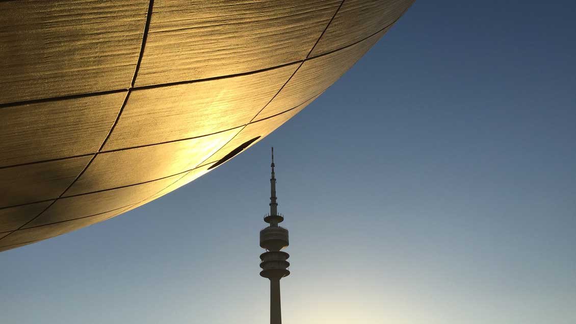 Spitz gegen rund? Alles eine Frage der Perspektive: Der Münchner Fernsehturm scheint die von goldener Abendsonne angestrahlte Hülle des BMW-Museums beinahe anzupieksen. Foto: Markus Nolte