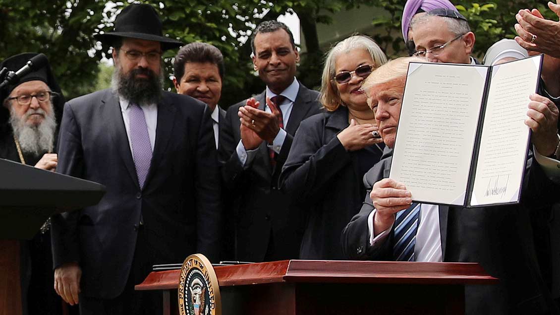 Donald Trump mit Religionsvertretern und dem neuen Dekret vor dem Weißen Haus in Washington.