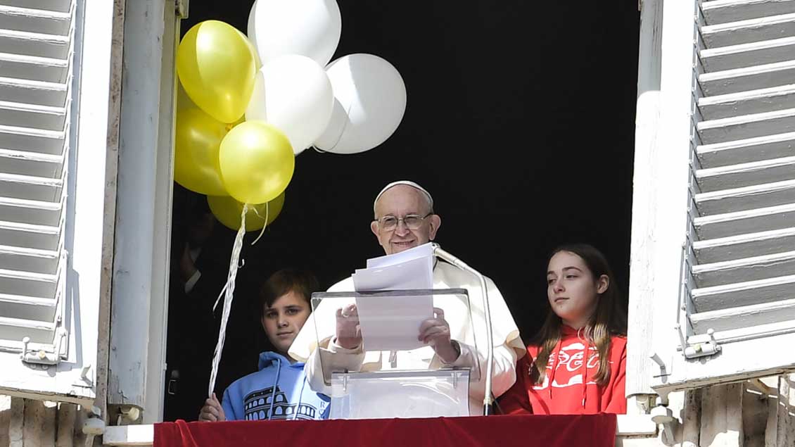 Papst Franziskus lässt mit Kindern Luftballons steigen.