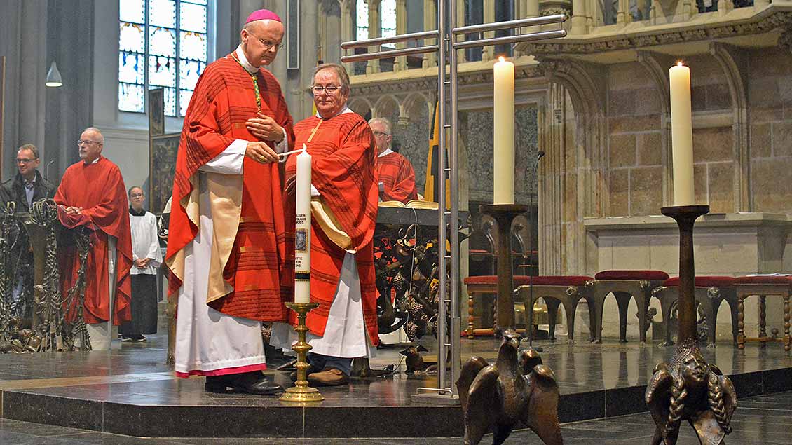 Bischof Overbeck entzündet im Xantener Viktor-Dom eine Kerze. Foto: Christian Breuer (pbm)