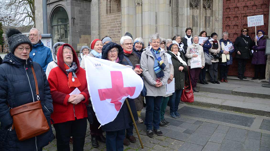 Mit violetten Kreuzen und Plakaten fordern rund 100 Frauen von KFD und "Maria 2.0" bildeten die Demonstranten ein Spalier, durch das die Teilnehmer des Gottesdienstes zum 50-jährigen Jubiläum des Ständigen Diakonats in den Xantener Dom gelangten.
