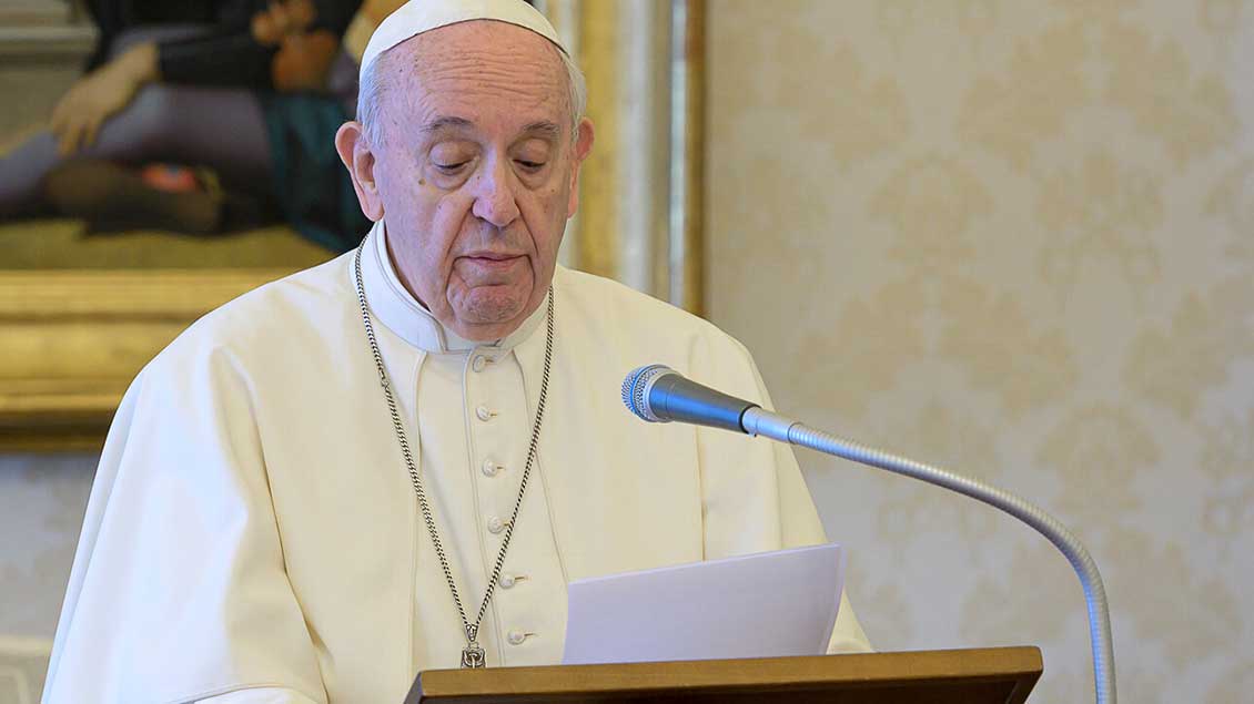 Papst Franziskus hinter Mikrofon und Lesepult