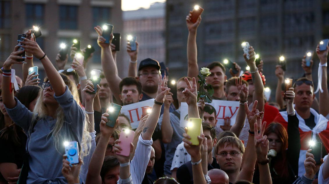 Demonstranten in Minskziegen die Lichter ihrer Smartphones.