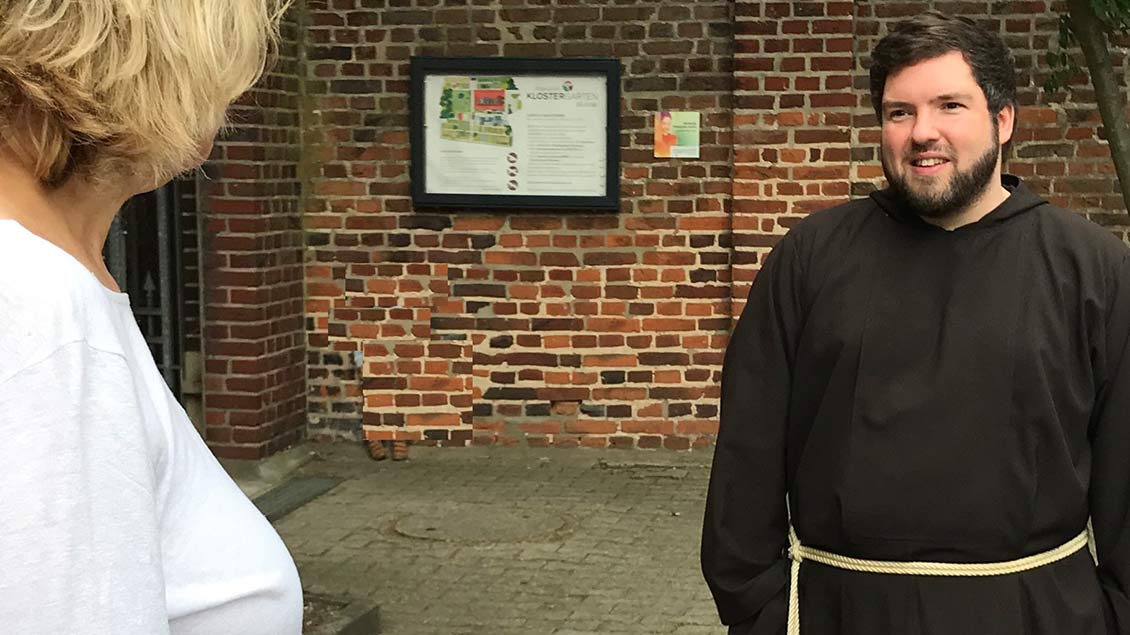 Kapuzinerbruder Jens spricht vor einer Kirche mit einer Frau. Foto: privat