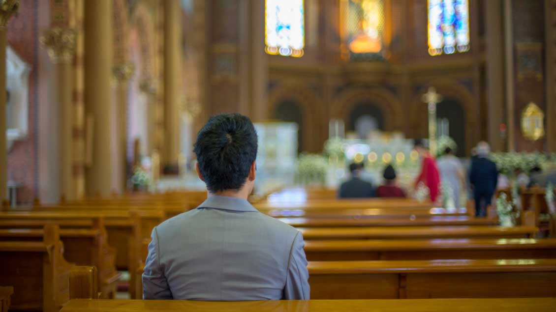 Einzelner Mann in einer Kirche Foto: Thoranin Nokyoo (Shutterstock)