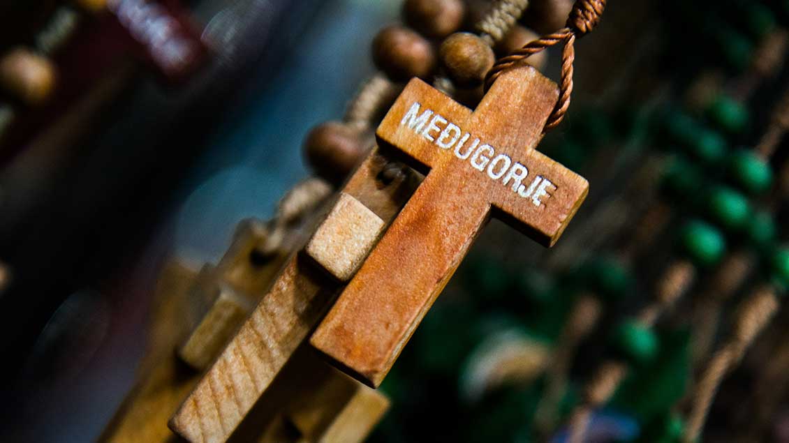 Holzkreuz an einem Rosenkranz mit der Aufschrift "Medjugorje". Foto: Clement Mahoudeau (KNA)