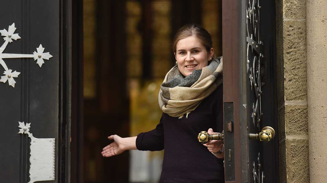 Junge Frau hält eine Kirchentür auf. Symbol-Foto: Michael Bönte