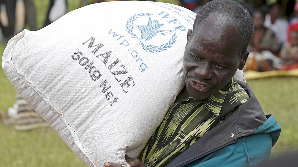 In Malawi trägt eine Einheimischer Nahrungsmittel des Welternährungsprogrammms. Foto: Reuters
