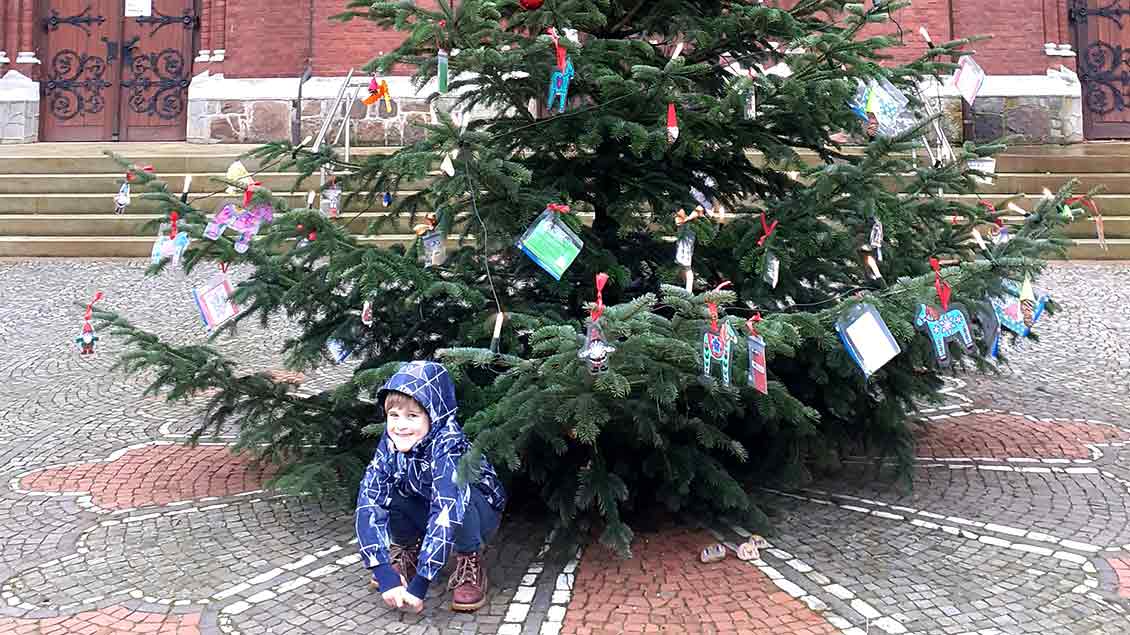 Der sechsjährige Tetje unter dem Tausch-Tannenbaum vor der Goldenstedter Kirche. | Foto: privat