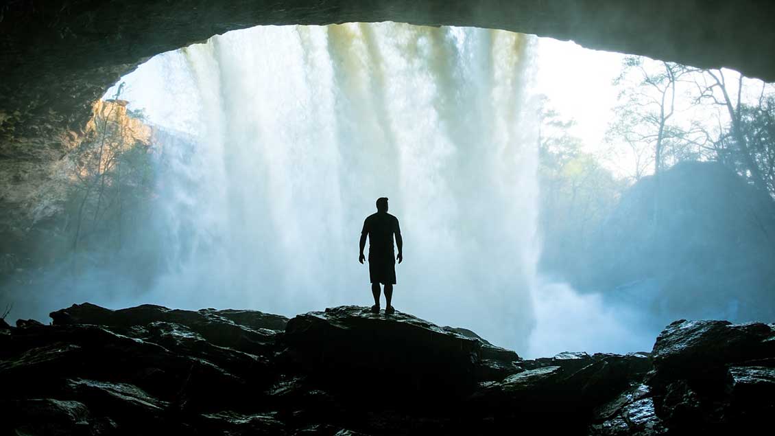 Mann vor einem Wasserfall