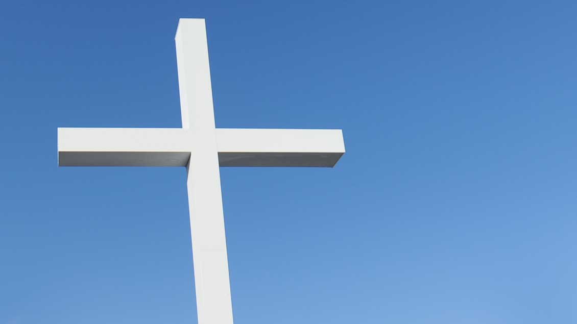 Weißes Kreuz vor blauem Himmel