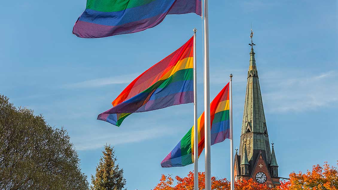 Regenbogenflaggen vor Kirchturm