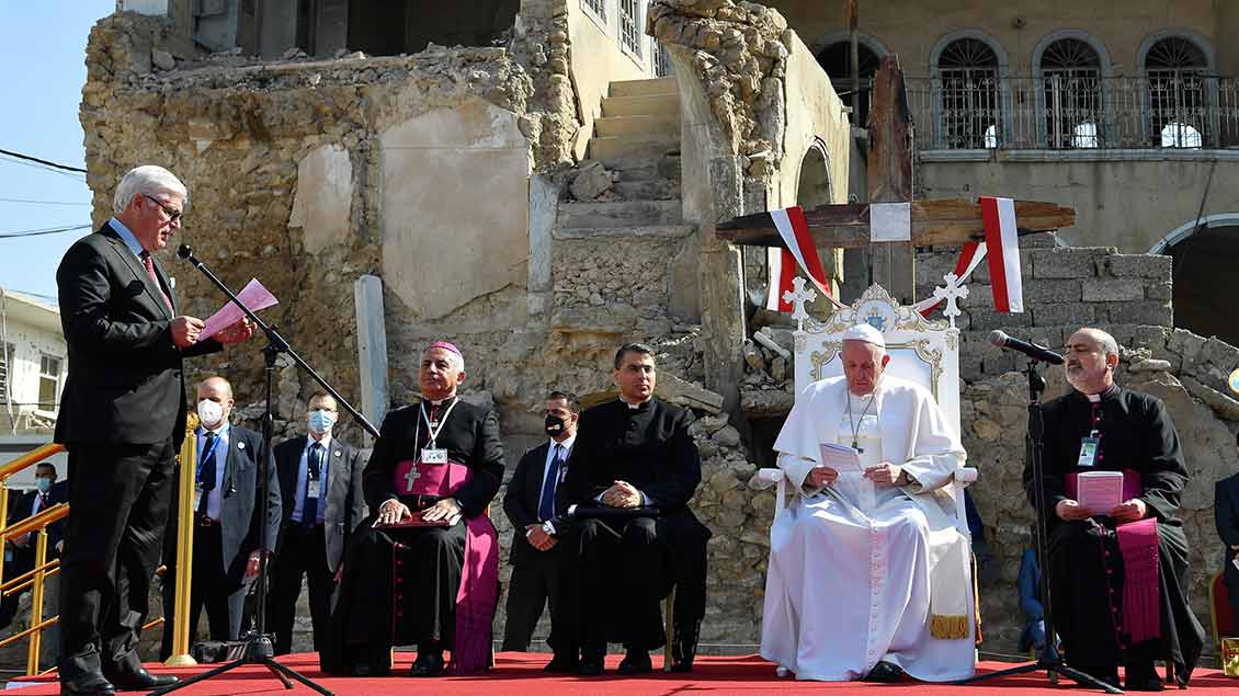 Papst Franziskus gedenkt in einer Zeremonie der Kriegsopfer in Mossul am 7. März 2021. Im Hintergrund steht ein zerstörtes Gebäude. Foto: Romano Siciliani (KNA)