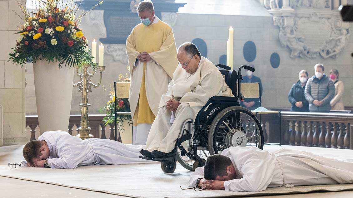 Als Zeichen der Hingabe an Gott liegen Tobias Eilert (links) und Lars Rother (rechts) ausgestreckt vor dem Altar, Matthias Fraune verbeugt sich. | Foto: Achim Pohl (pbm)