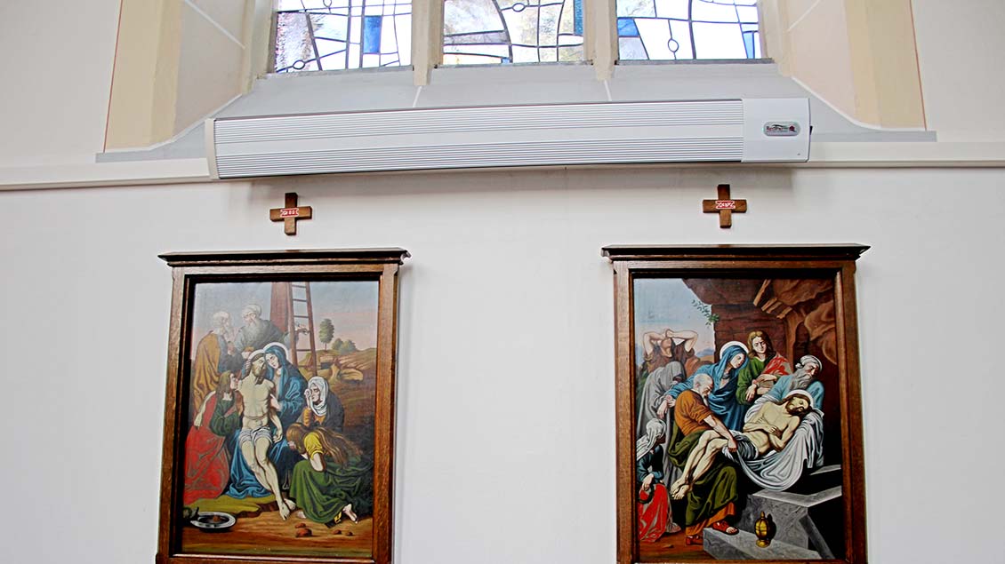 Die Heizstrahler sind an den Wänden des Kirchenraums angebracht wie hier über den Bildnissen des Kreuzwegs. | Foto: Johannes Bernard