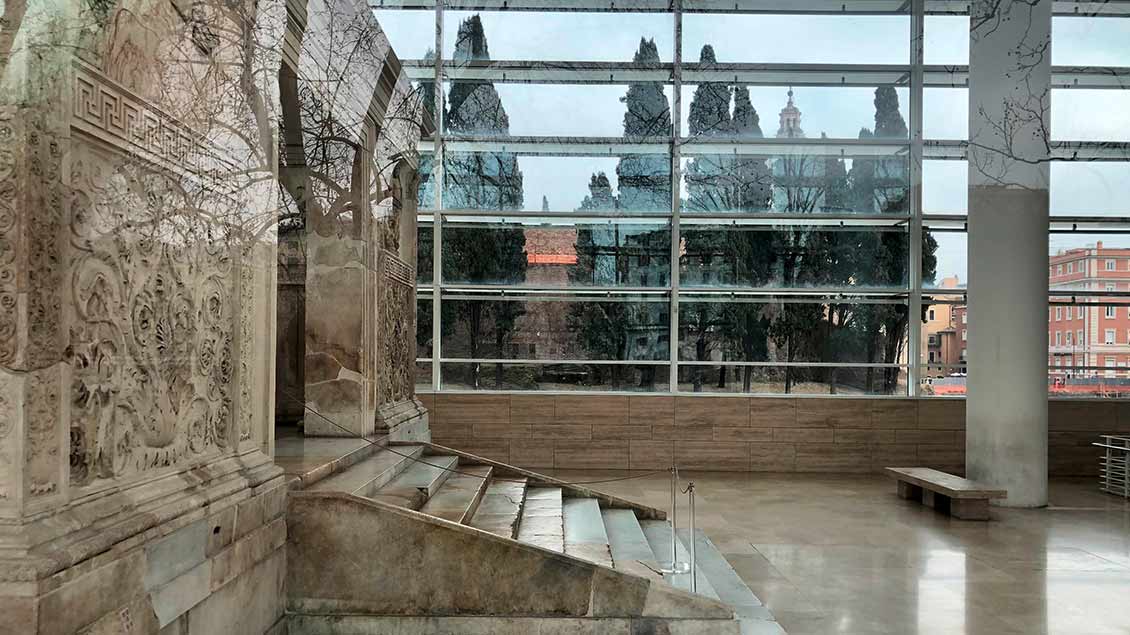 Durch das Ara-Pacis-Museum von Richard Meier sieht man an Augustus‘ Friedensaltar vorbei auf das Mausoleum. | Foto: Kerstin Thiel-Lunghini