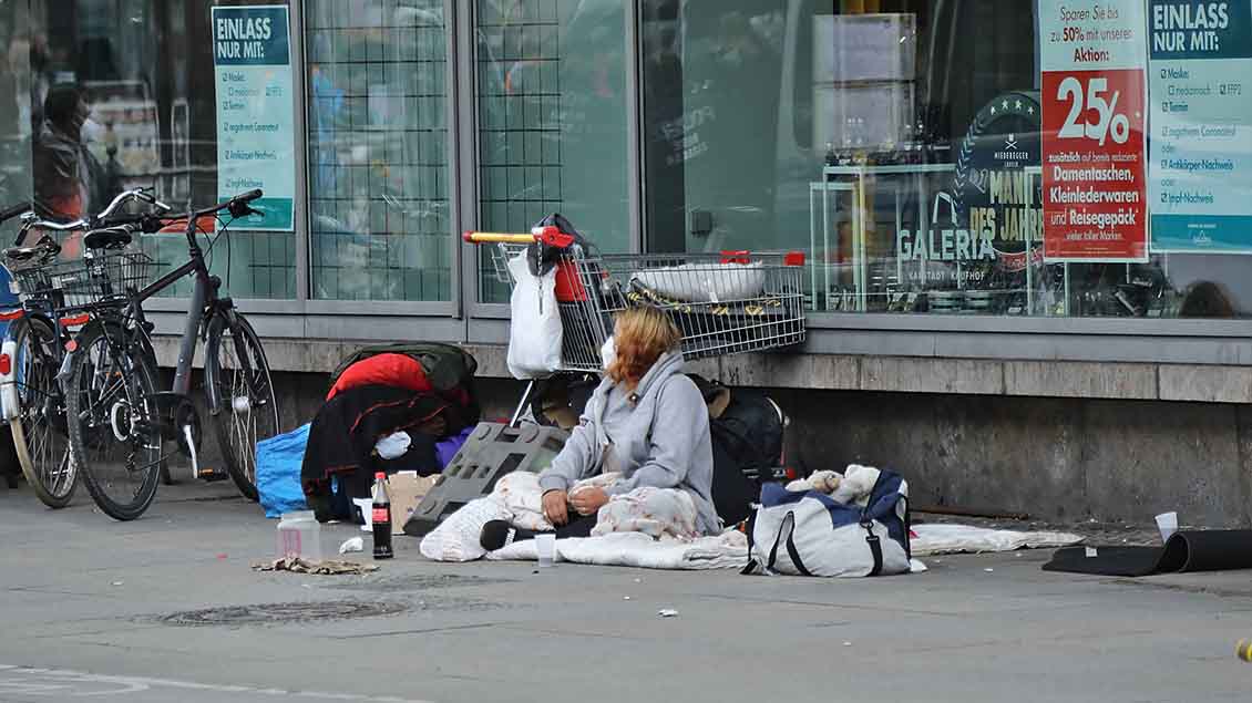 Eine Obdachlose sitzt vor einem Kaufhaus. Foto: Bernd Elmenthaler (imago)