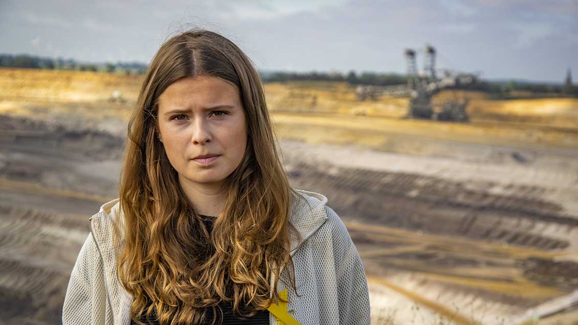Luisa Neubauer steht vor einem Braunkohle-Tagebau. Foto: Chromorange (Imago)