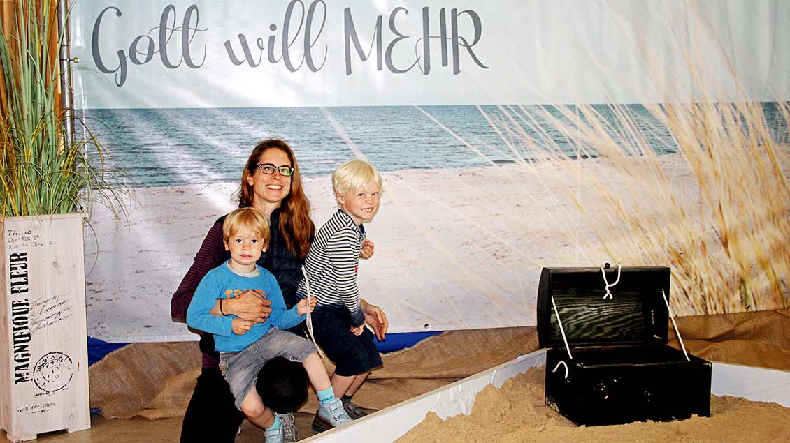 Anne Schlee und ihre Kinder sind begeistert vom Kirchen-Strand „Gott will MEHR“. | Foto: Johannes Bernard