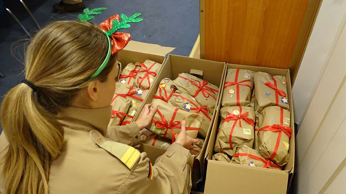 Eine Soldatin packt aus und verteilt: amtliche Weihnachtsgeschenke aus Berlin. | Foto: Bundeswehr