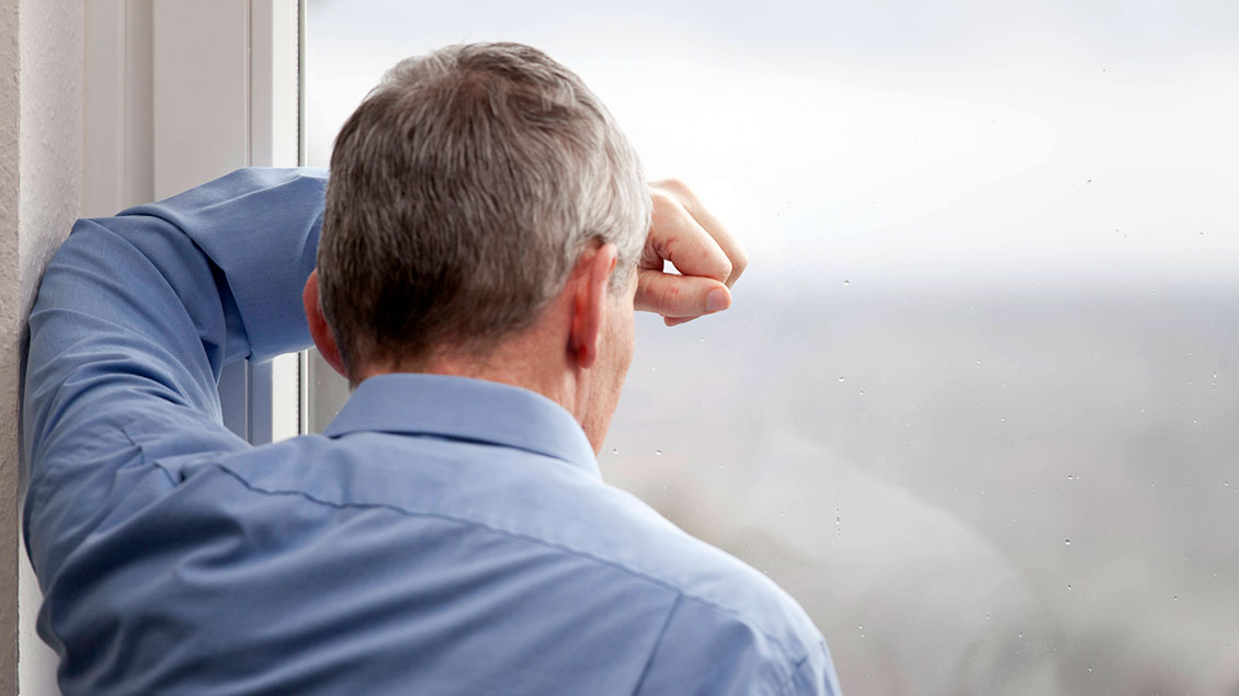 Mann vor einem verregneten Fenster Foto: Shotshop (imago)