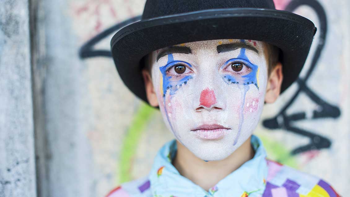 Trauriger Junge als Clown verkleidet Foto: Imago