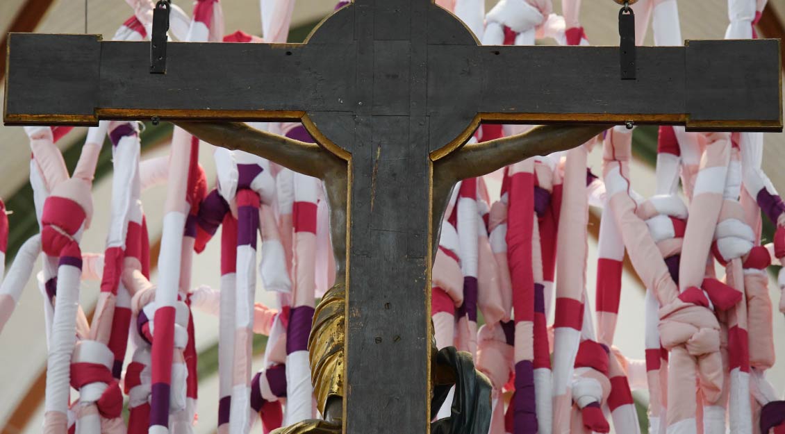Das Kreuz ist hinter den buten Stoffen zu sehen.