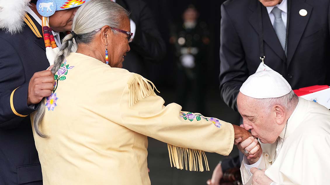 Papst Franziskus küsst die Hand eines Indigenenvertreters in Kanada