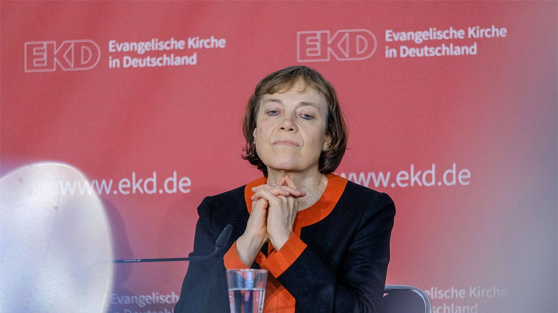 Annette Kurschus sitzt nachdenklich vor einer Stellwand. Jens Schulze (IMAGO)